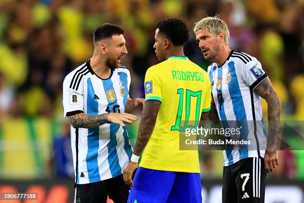 Lionel Messi of Argentina and teammate Rodrigo de Paul talk to Rodrygo of Brazil after the match was delayed due to incidents in the stands during a...