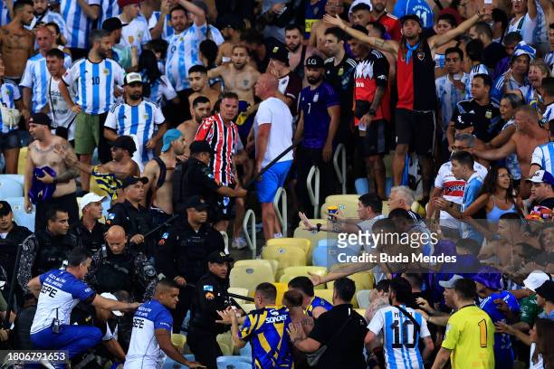 Police officers armed with batons clash with fans as the match is delayed due to the incidents prior to a FIFA World Cup 2026 Qualifier match between...