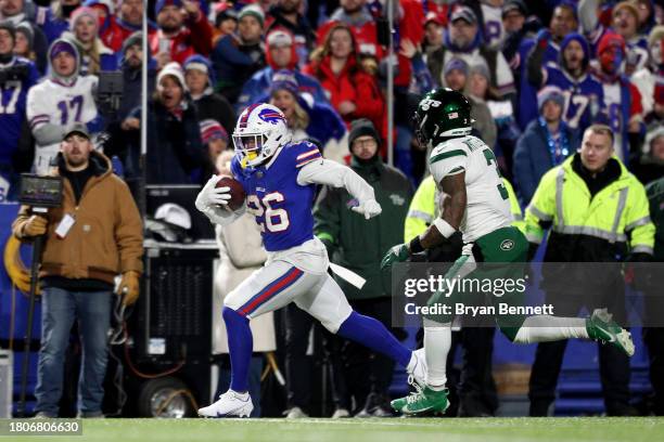 Ty Johnson of the Buffalo Bills runs the ball as Jordan Whitehead of the New York Jets attempts to pursue him during the third quarter at Highmark...