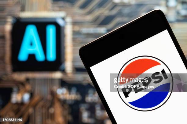 In this photo illustration, the carbonated soft drink with a cola flavor, manufactured by PepsiCo, Pepsi, logo seen displayed on a smartphone with an...