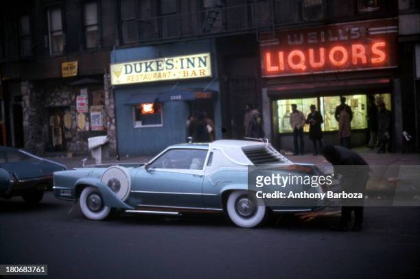 View of a heavily customized 1973 Cadillac Eldorado 'pimpmobile' parked on a street in Harlem, New York, New York, 1970s.