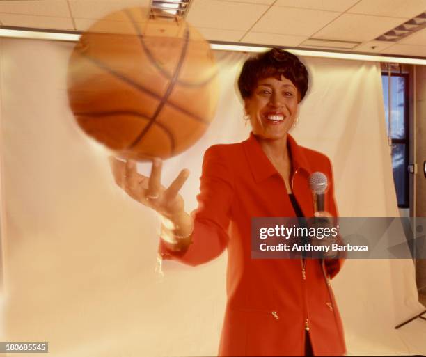 Portrait of American broadcast journalist Robin Roberts as she poses with a basketball in one hand and a microphone in the other, New York, New York,...
