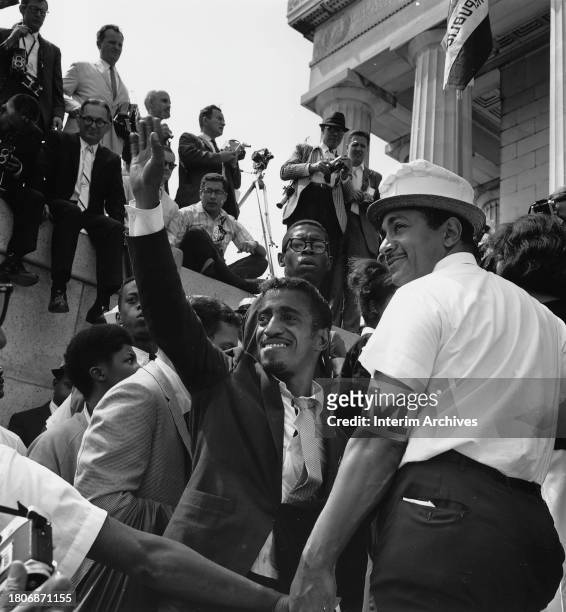 African American actor and singer Sammy Davis Jr , center, smiles and waves to the crowd while participating in the March on Washington, Washington,...
