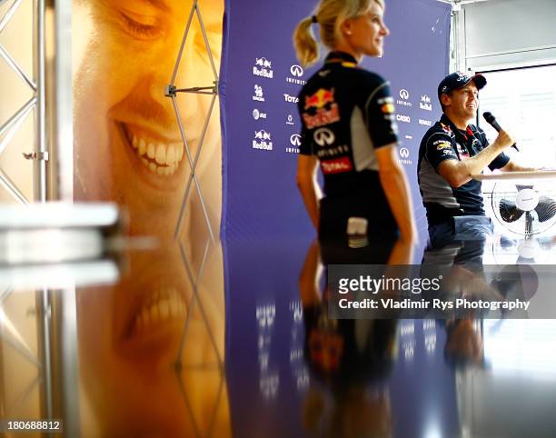 Sebastian Vettel of Germany and Infiniti Red Bull Racing and his press officer Britta Roeske are seen attend a media session during previews to the...