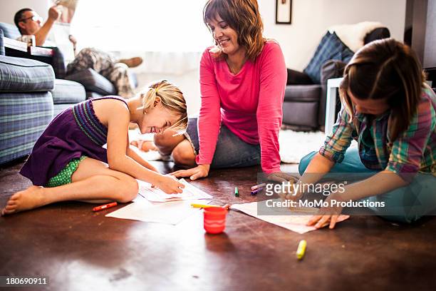 girls coloring with mother - sitting on floor bildbanksfoton och bilder