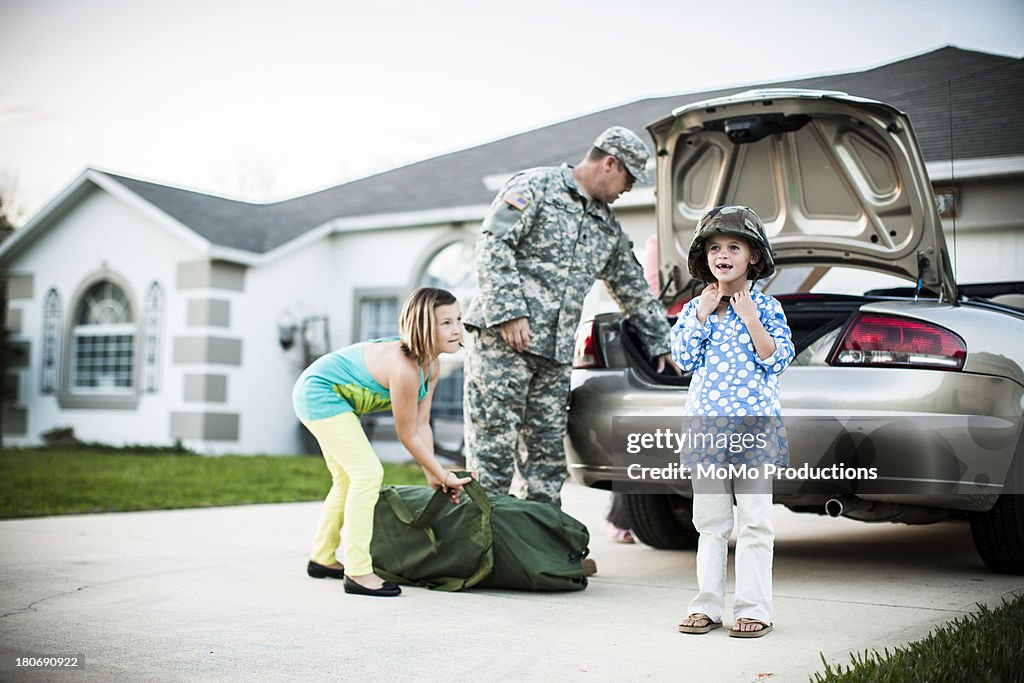 Daughter wearing father's army helmet