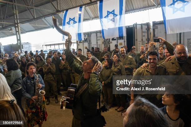 Noam Buskili blows the shofar as people dance during the wedding IDF officer Daniel and his bride Kochava on November 21, 2023 in Northern Israel....