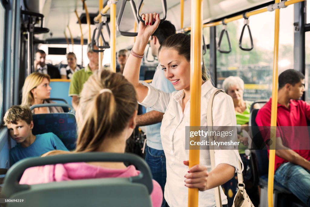 Young woman talking to her friend on bus.