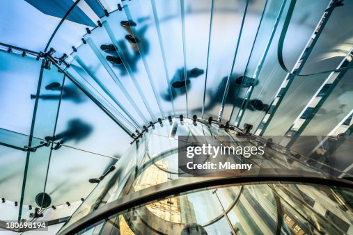 People walking on transparent glass staircase People walking on transparent glass staircase