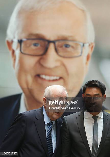 German Free Democrats lead candidate Rainer Bruederle and FDP party chairman Philipp Roesler walk past an FDP election campaign poster as they arrive...
