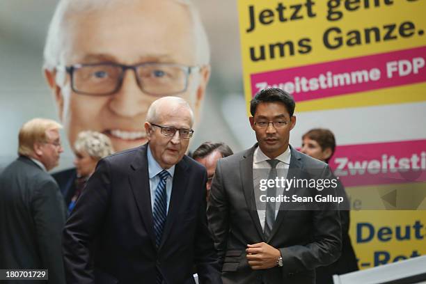 German Free Democrats lead candidate Rainer Bruederle and FDP party chairman Philipp Roesler walk past an FDP election campaign poster as they arrive...