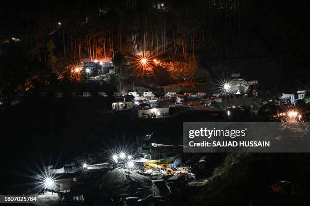 Ambulance and emergency vehicles are seen on standby near the entrance of the under construction Silkyara tunnel during a rescue operation for...