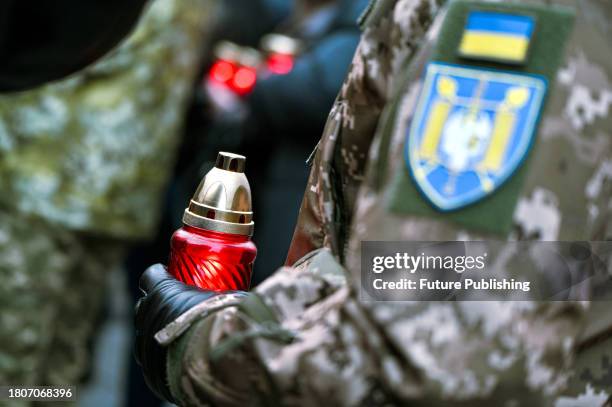 Serviceman holds a vigil lantern during a national moment of silence and an ecumenical memorial service for the victims of the 20th-century famines...