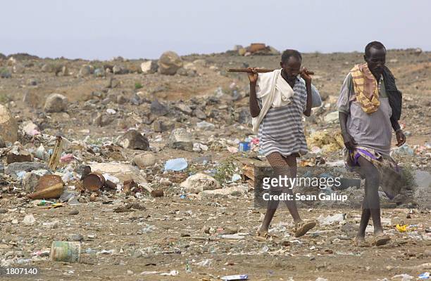 Two men walk near the Baal-Balla slum February 21, 2003 in the outskirts of Djibouti Town, Djibouti. Baal-Balla is one of many Djibouti slums swollen...