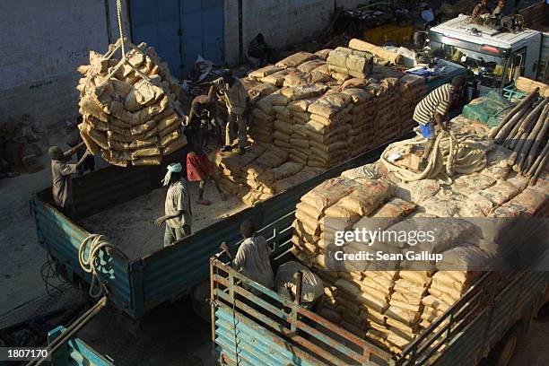 Dock workers load U.S.-donated bags of wheat destined for Ethiopia onto trucks February 21, 2003 in Djibouti Town, Djibouti. The Food and...