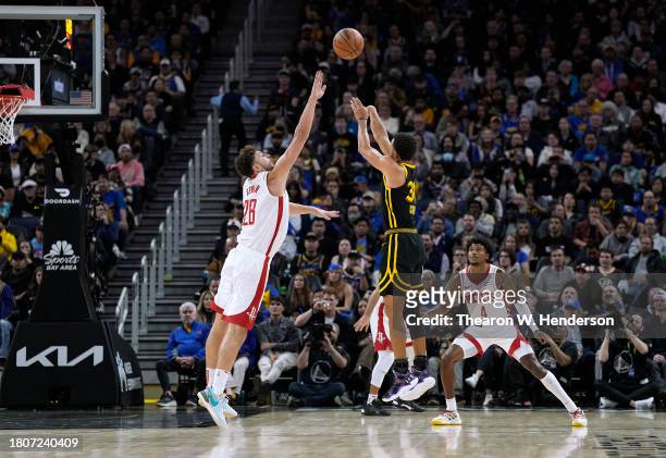 Stephen Curry of the Golden State Warriors shoots a three-point shot over Alperen Sengun of the Houston Rockets during the third quarter of an NBA...