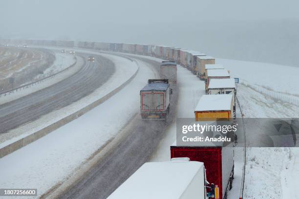 Snow-covered trucks stand in a long, over 7km long queue near Bidovce, Slovakia on November 28, 2023. The recently arrived wintery conditions...