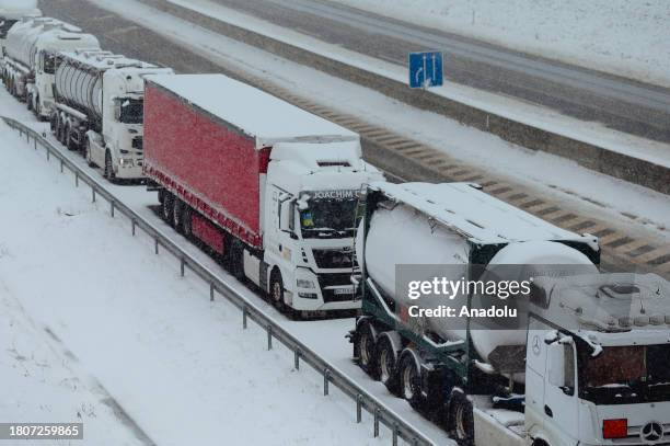 Snow-covered trucks stand in a long, over 7km long queue near Bidovce, Slovakia on November 28, 2023. The recently arrived wintery conditions...