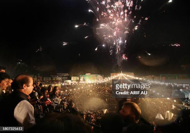 Pakistani former prime minister Nawaz Sharif watches fire works during his arrival at an election campaign public meeting in Faisalabad, 10 December...
