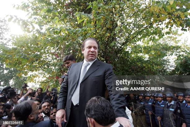 Former Pakistani prime minister Nawaz Sharif climbs on a barricade after he was stopped by riot police near the residence of deposed chief justice...