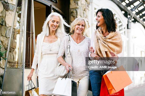 trio of beautiful mature women shopping - beauty shopping stockfoto's en -beelden