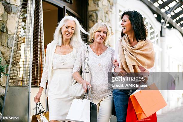 trio of beautiful mature women shopping - seniors shopping stock pictures, royalty-free photos & images