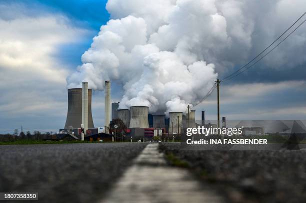 Vapor rises from the cooling towers of the lignite-fired power station operated by German energy giant RWE in Niederaussem, western Germany on...