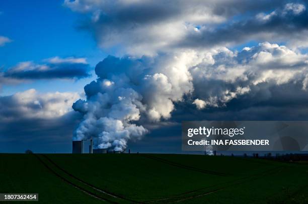 Vapor rises from the cooling towers of the lignite-fired power station operated by German energy giant RWE in Niederaussem, western Germany on...