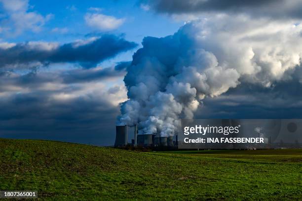 Vapor rises from the cooling towers of the lignite-fired power station operated by German energy giant RWE in Niederaussem, western Germany on...