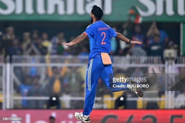 India's Arshdeep Singh celebrates after taking the wicket Australia's Aaron Hardie during the third Twenty20 international cricket match between...