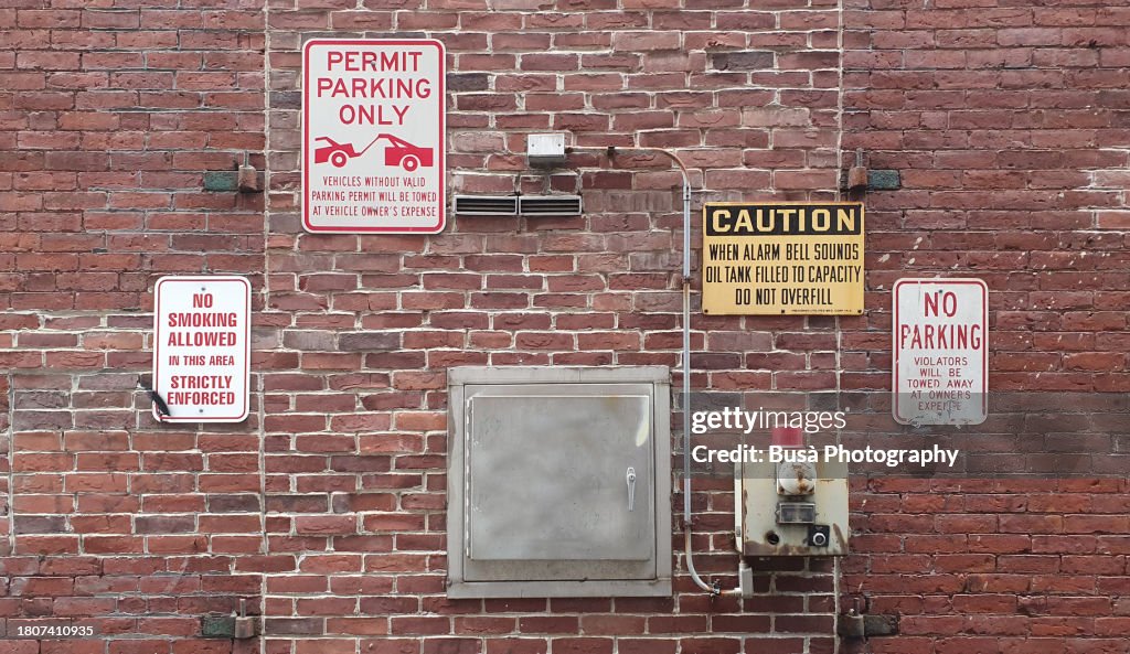 Closeup of industrial brick wall with warning signs on it