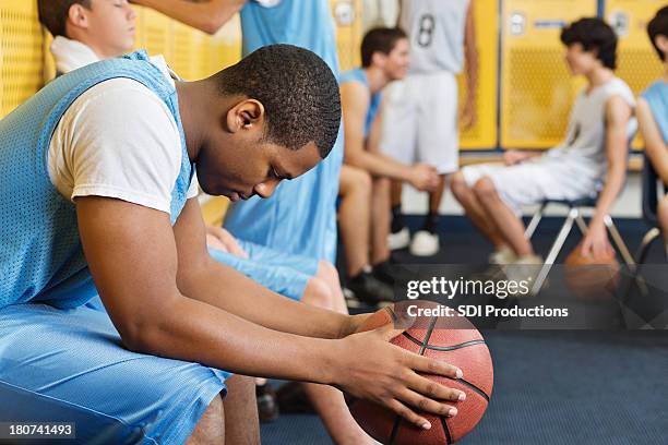 high school umkleideraum mit basketball-spieler - black and white sad boy stock-fotos und bilder
