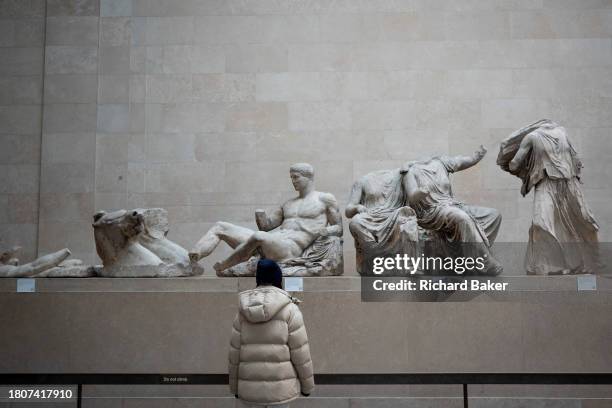 Visitors in the Parthenon Galleries in London's British Museum where visitors admire the Ancient Greek Parthenon Metopes also knows as the Parthenon...