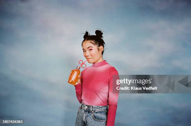 young woman drinking juice from bottle - soda photos et images de collection