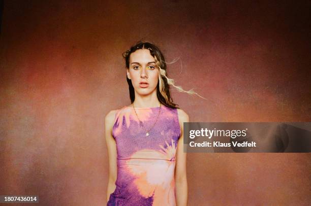 young woman against brown background - blank expression stock pictures, royalty-free photos & images