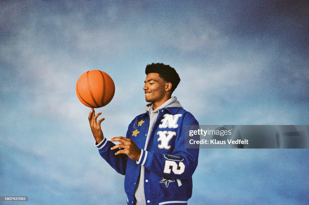 Boy spinning basketball on finger