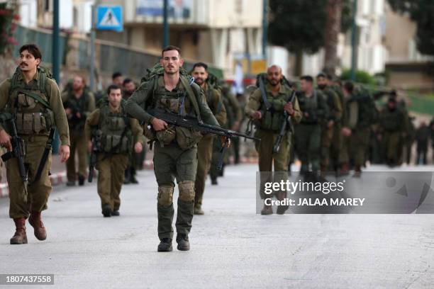 Israeli troops take part in a military drill in the Israeli city of Kiryat Shmona near the border with Lebanon on November 28, 2023.