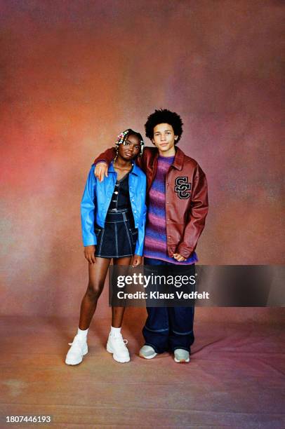 male and female friends near brown backdrop - striped tshirt stock pictures, royalty-free photos & images