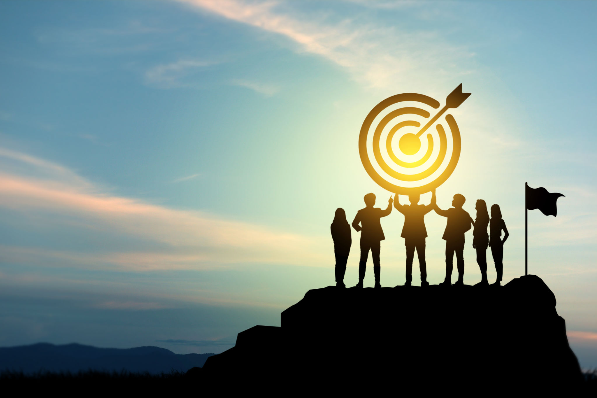 Goal setting towards planning for the future. Silhouettes of group businessmen holding target boards with flags planted on a mountain. Goal setting towards planning for the future. Silhouettes of group businessmen holding target boards with flags planted on a mountain.
