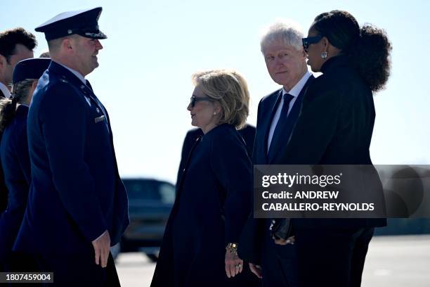 Former US Secretary of State Hillary Clinton, former US President Bill Clinton, and former US First Lady Michelle Obama are greeted upon arrival at...