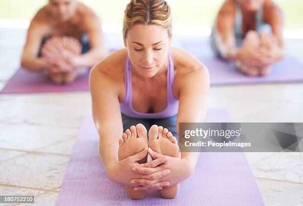 deep relaxation through yoga - touching toes stock pictures, royalty-free photos & images