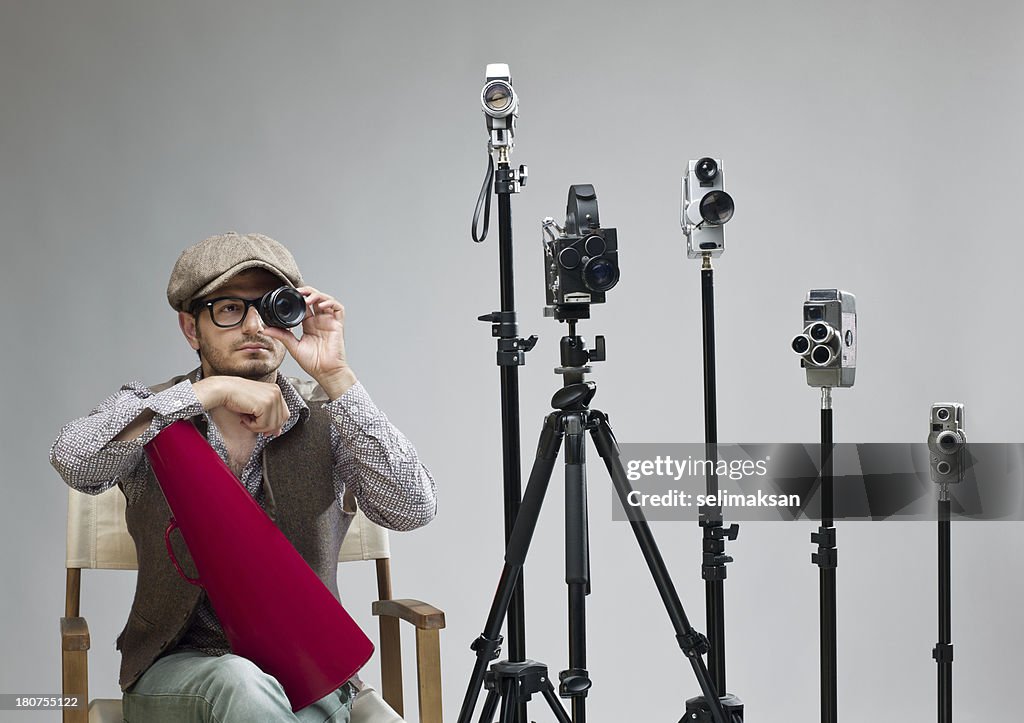Film director behind camera holding lens for testing