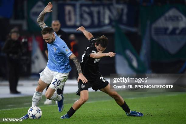 Lazio's Italian midfielder Manuel Lazzari fights for the ball with Celtic's Portuguese midfielder Paulo Bernardo during the UEFA Champions League...