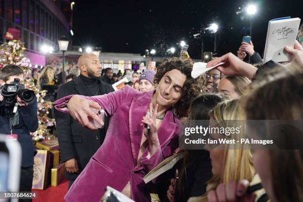 Timothee Chalamet takes selfies with fans as he arrives for the world premiere of Wonka at the Royal Festival Hall in London. Picture date: Tuesday...