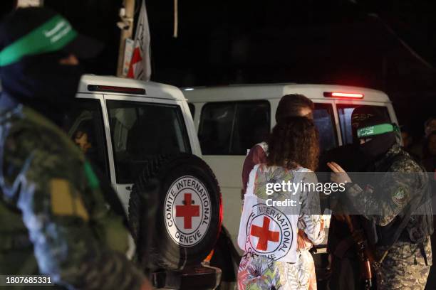 Hamas and Islamic Jihad fighters speak with members of the Red Cross during the release of hostages in Rafah, in the southern Gaza Strip on November...