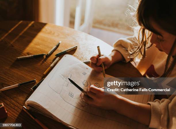 a child doodles on a sheet of lined paper using colourful crayons - sketch pen stock pictures, royalty-free photos & images