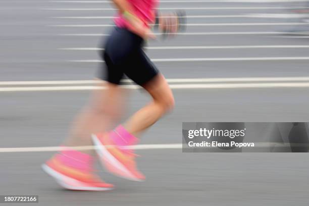 low section blurred motion female triathlete running fast in the city - woman marathon stock pictures, royalty-free photos & images