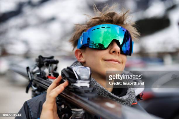 porträt eines coolen jugendlichen skifahrers mit seinen skiern - mirrored sunglasses stock-fotos und bilder