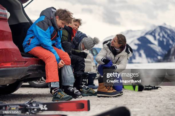 family taking off ski gear after skiing in european alps - skidsemester bildbanksfoton och bilder