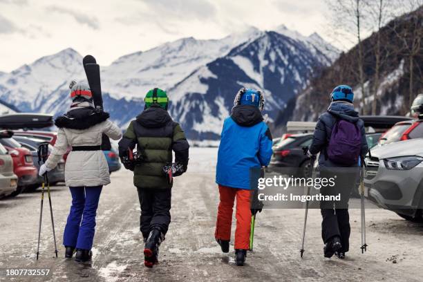 familie kehrt nach dem skifahren in den europäischen alpen zum auto zurück - skistiefel stock-fotos und bilder